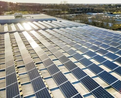 Commercial solar panels with sun shining on them