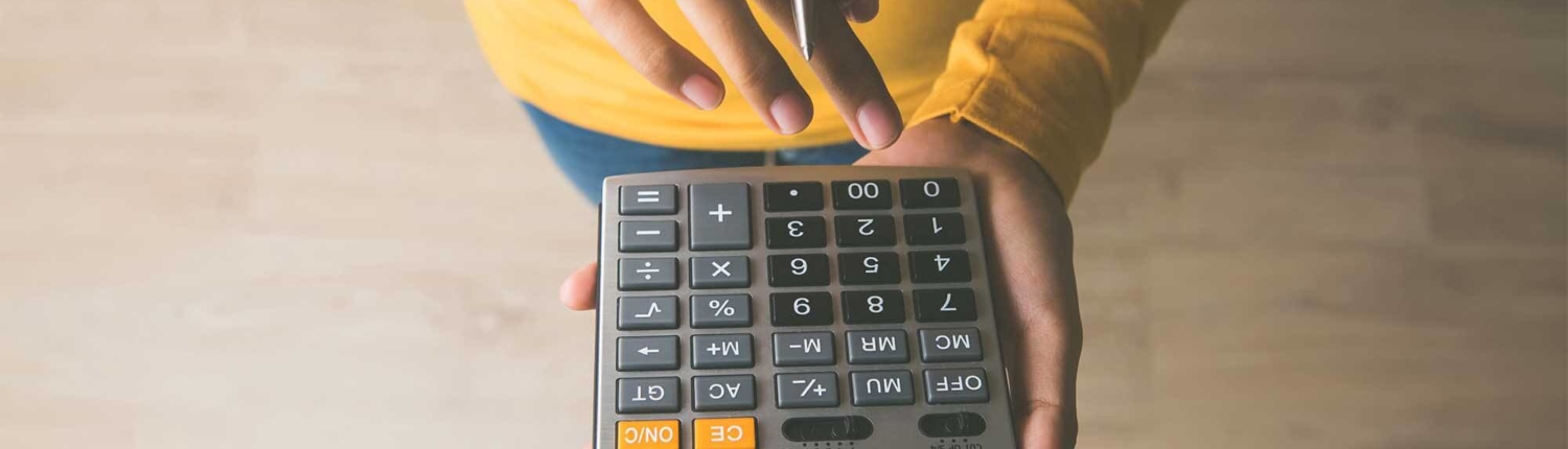 Pace Financing_AprilBlog2 Person holding a pen and a calculator
