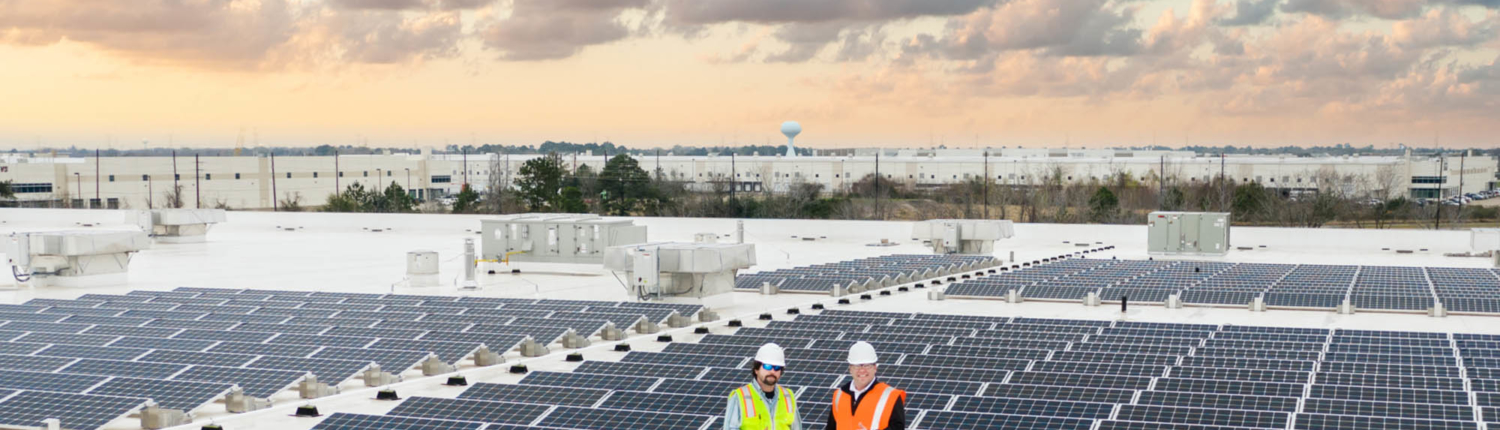 O3 team standing on top of a building with solar panels