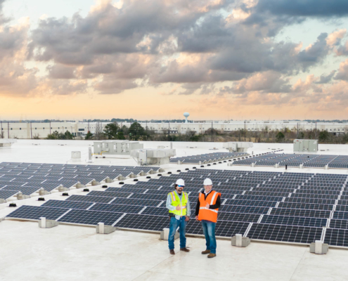 O3 team standing on top of a building with solar panels